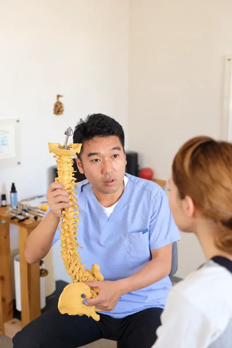 背骨模型を使って身体の状態を説明している様子
